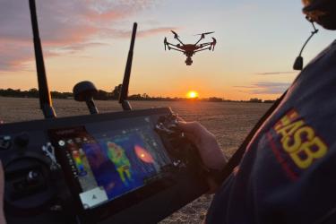 Drohne im Sonnenuntergang mit Pilot