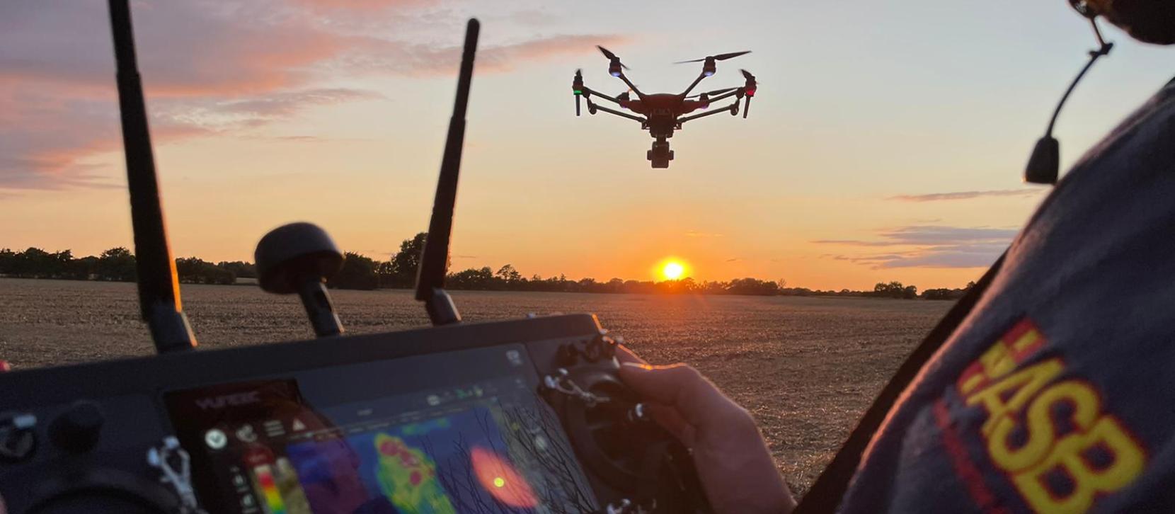 Drohne im Sonnenuntergang mit Pilot