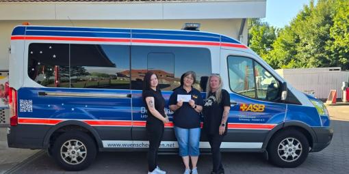 Spendenübergabe mit Wünschewagen an der Tankstelle